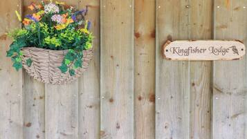 A wooden sign with the text "Kingfisher Lodge" and a bird silhouette.