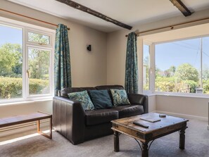 A living room with a leather sofa, a wooden coffee table, and a bench. - Woodstock (Chard)