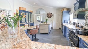 A modern kitchen with granite countertops, a central island, and blue cabinetry.