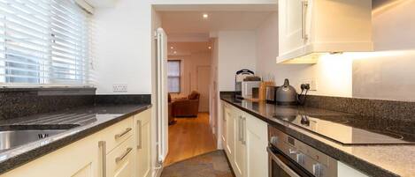 A modern kitchen with granite countertops, stainless steel appliances, and a central island.