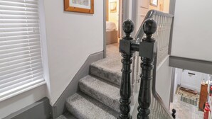 A staircase with a handrail and a framed picture on the wall. - The Corner House (Londonderry)