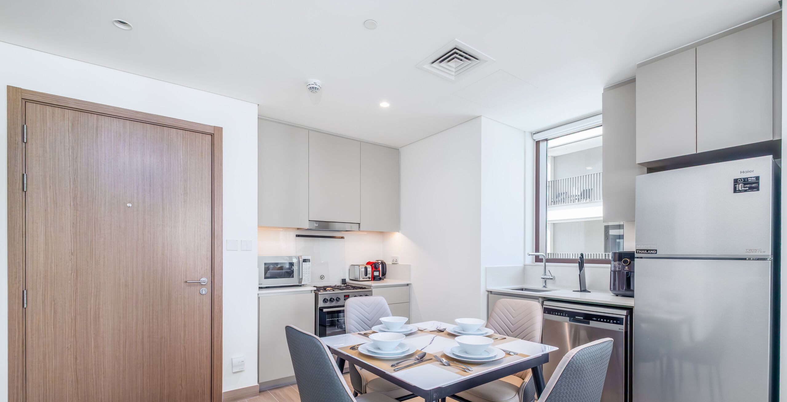 A modern kitchen with a dining area, including a stove, microwave, and refrigerator.