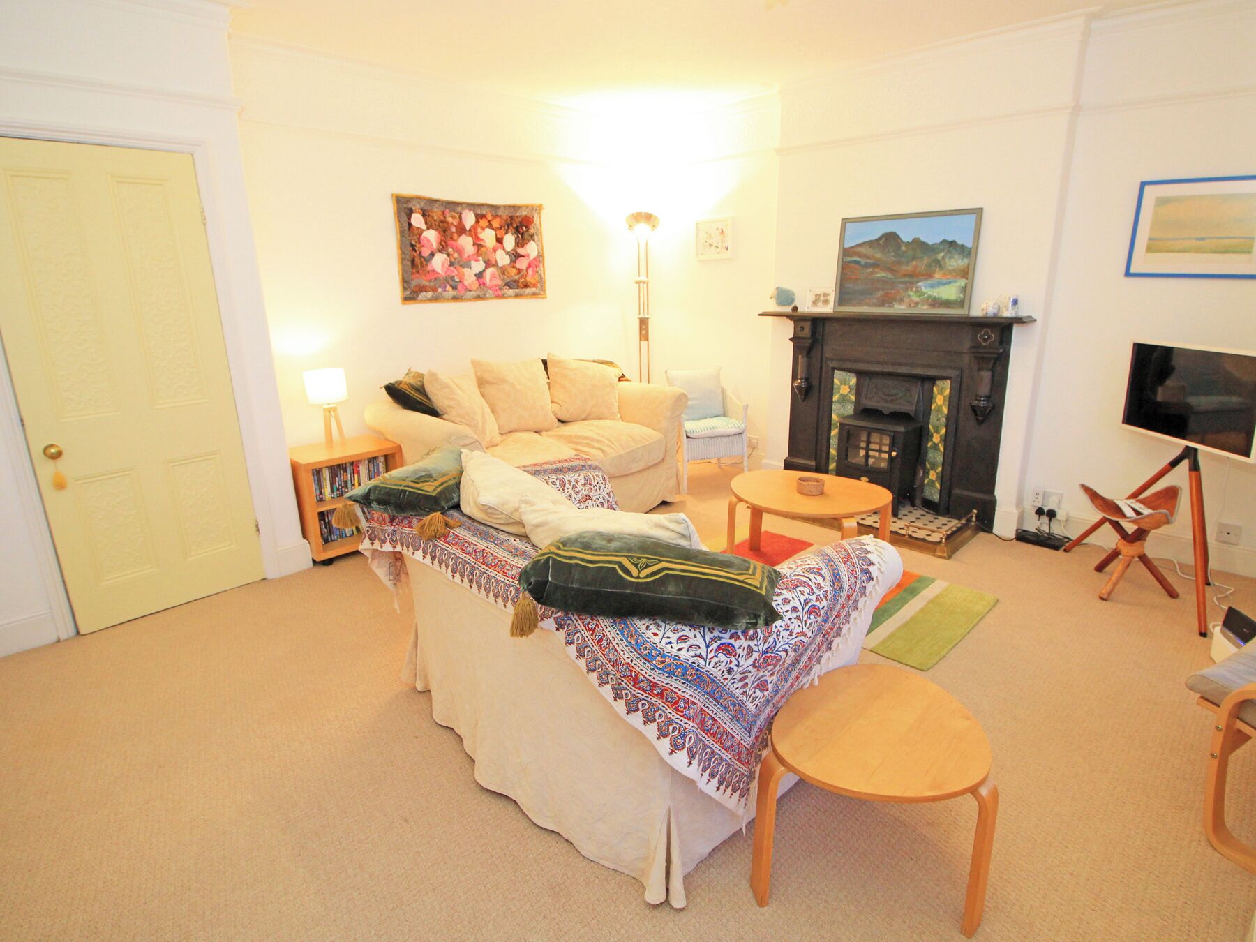 A cozy living room with a sofa, armchairs, a fireplace, and a television.