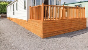 Una casa mobile con una veranda in legno e un portico coperto.