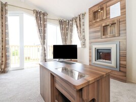 A modern living room with a wooden entertainment center, a flat-screen TV, and a fireplace.