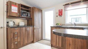 Una cucina moderna con mobili in legno, un forno a microonde, un tostapane e un lavandino.