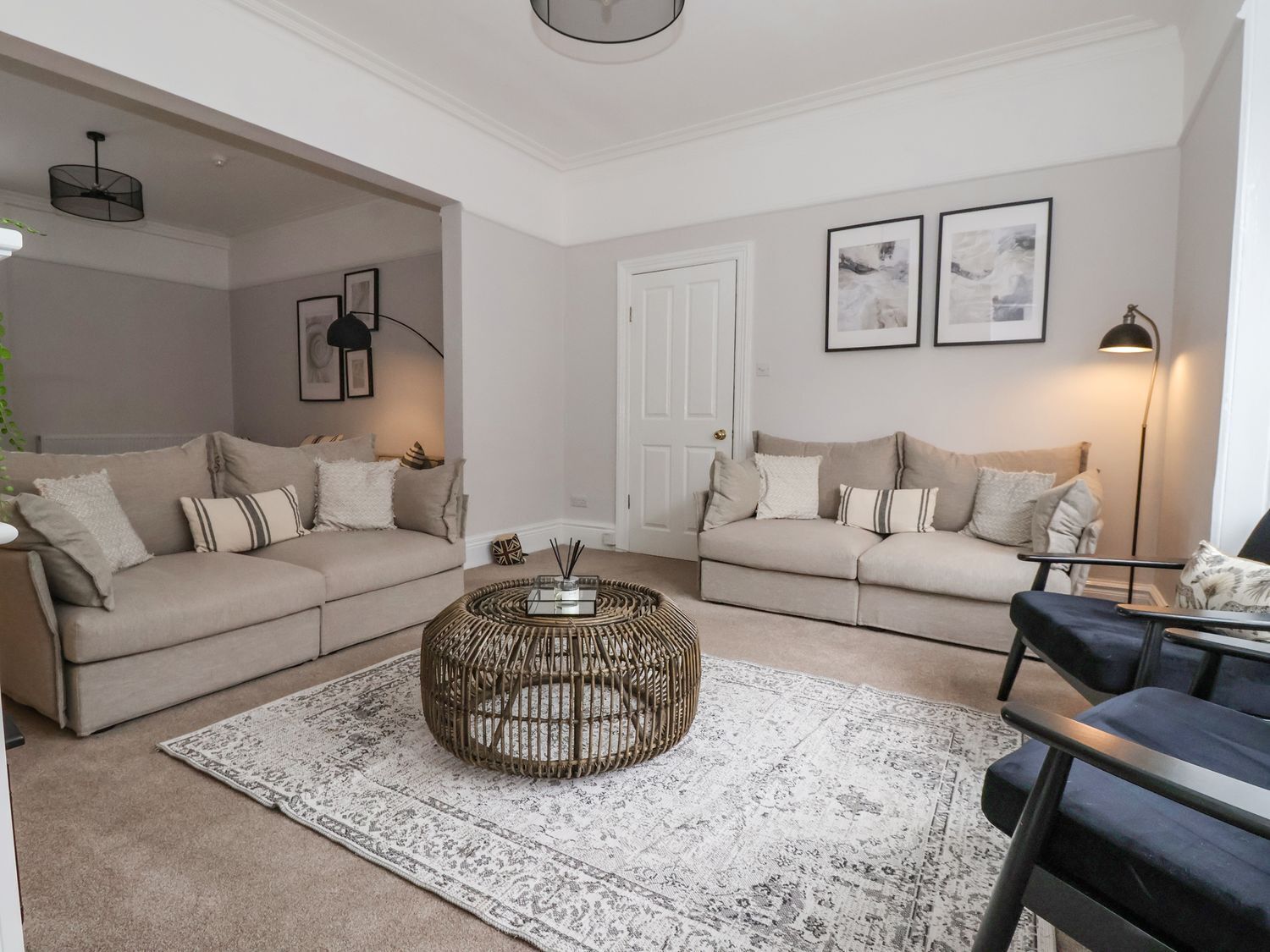 A living room with two sofas, a coffee table, and a patterned rug.