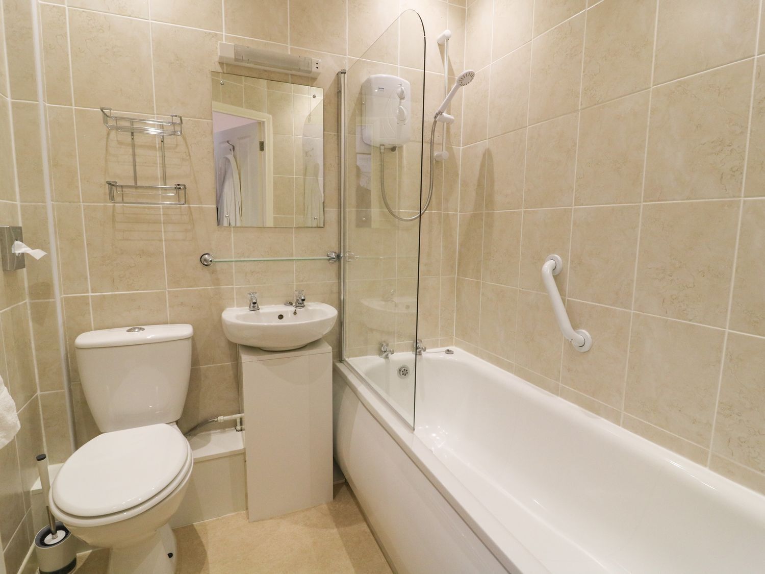 Un baño con inodoro, lavamanos y bañera.