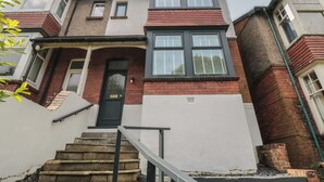 A two-story residential building with a front entrance, a staircase, and a small porch area. - Thirty Four By the Sea (Scarborough)