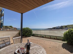 A patio with a table set for two, overlooking a beach. - 6 Burgh Island (Kingsbridge)