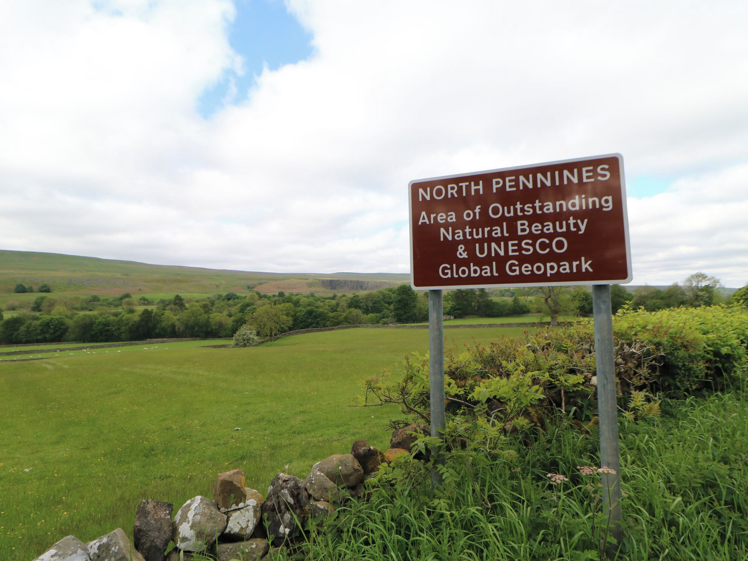 Ein Schild, das die North Pennines als Gebiet außergewöhnlicher natürlicher Schönheit und UNESCO-Globalen Geopark kennzeichnet.