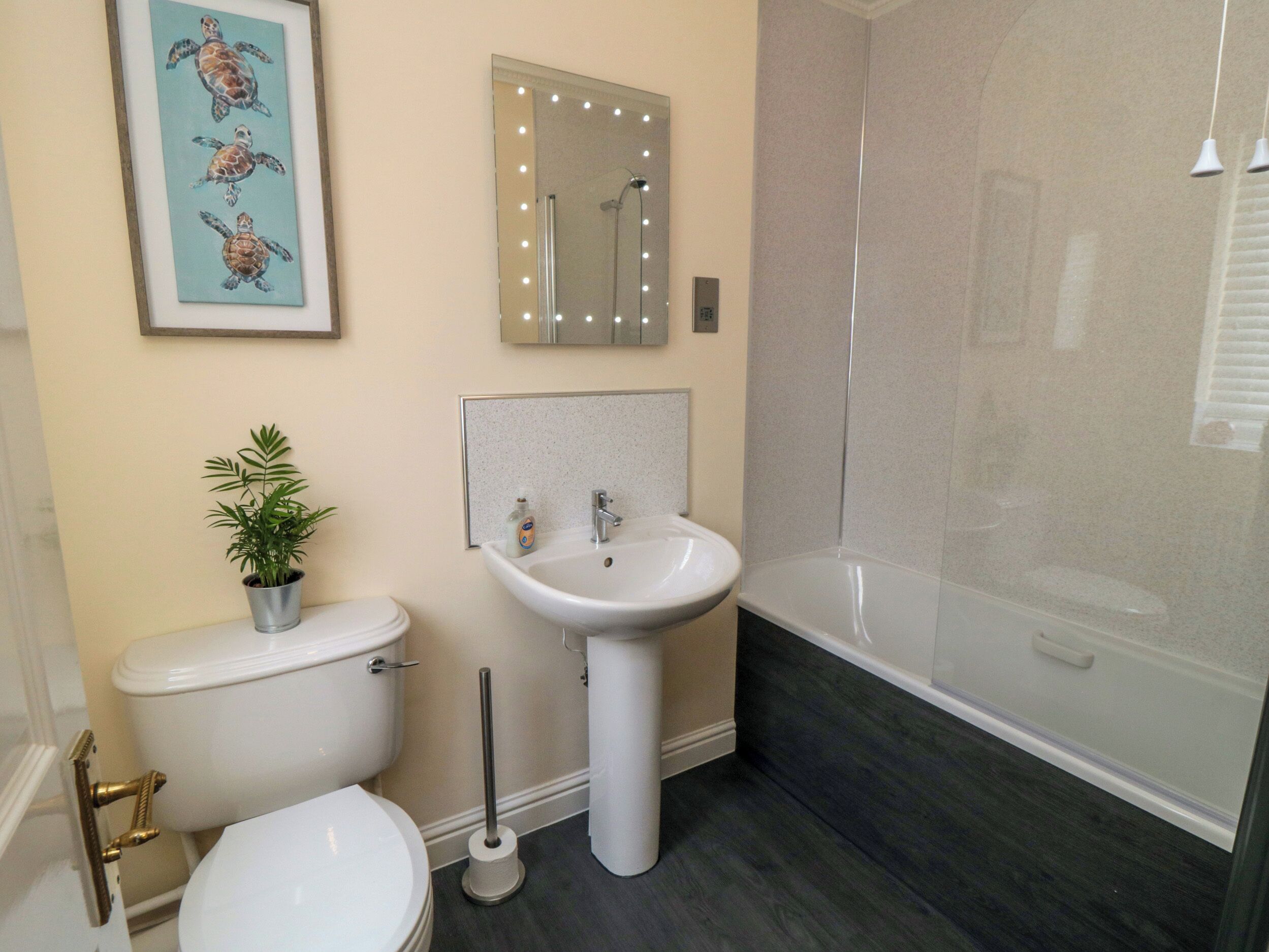 A bathroom with a toilet, sink, and shower.