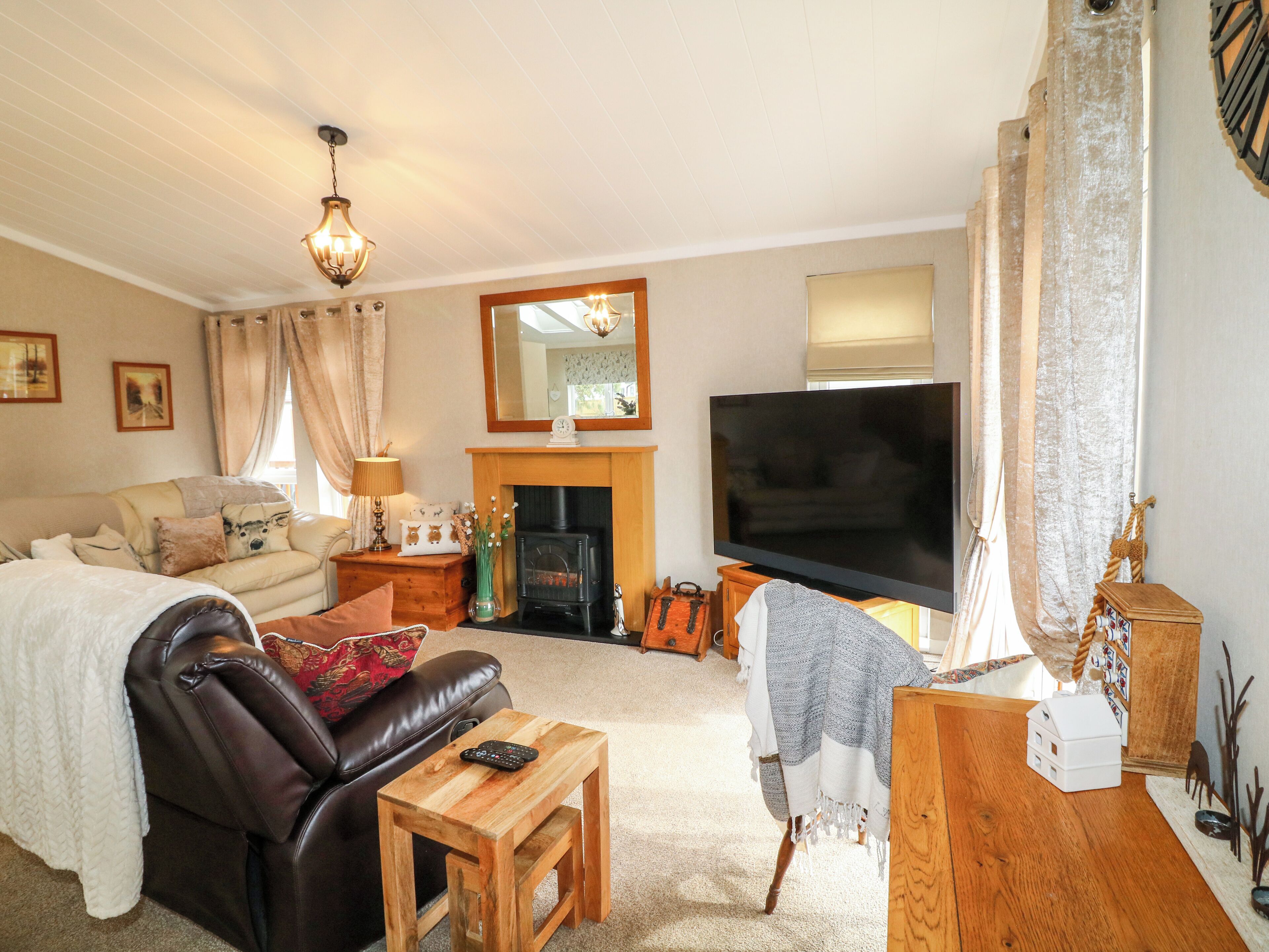Una sala de estar acogedora con chimenea, televisor y zona de estar cómoda.