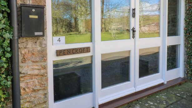 A white double door with glass panels, a number '4' sign, and a 'PEN CROFT' label. - Pencroft Cottage (Leyburn)
