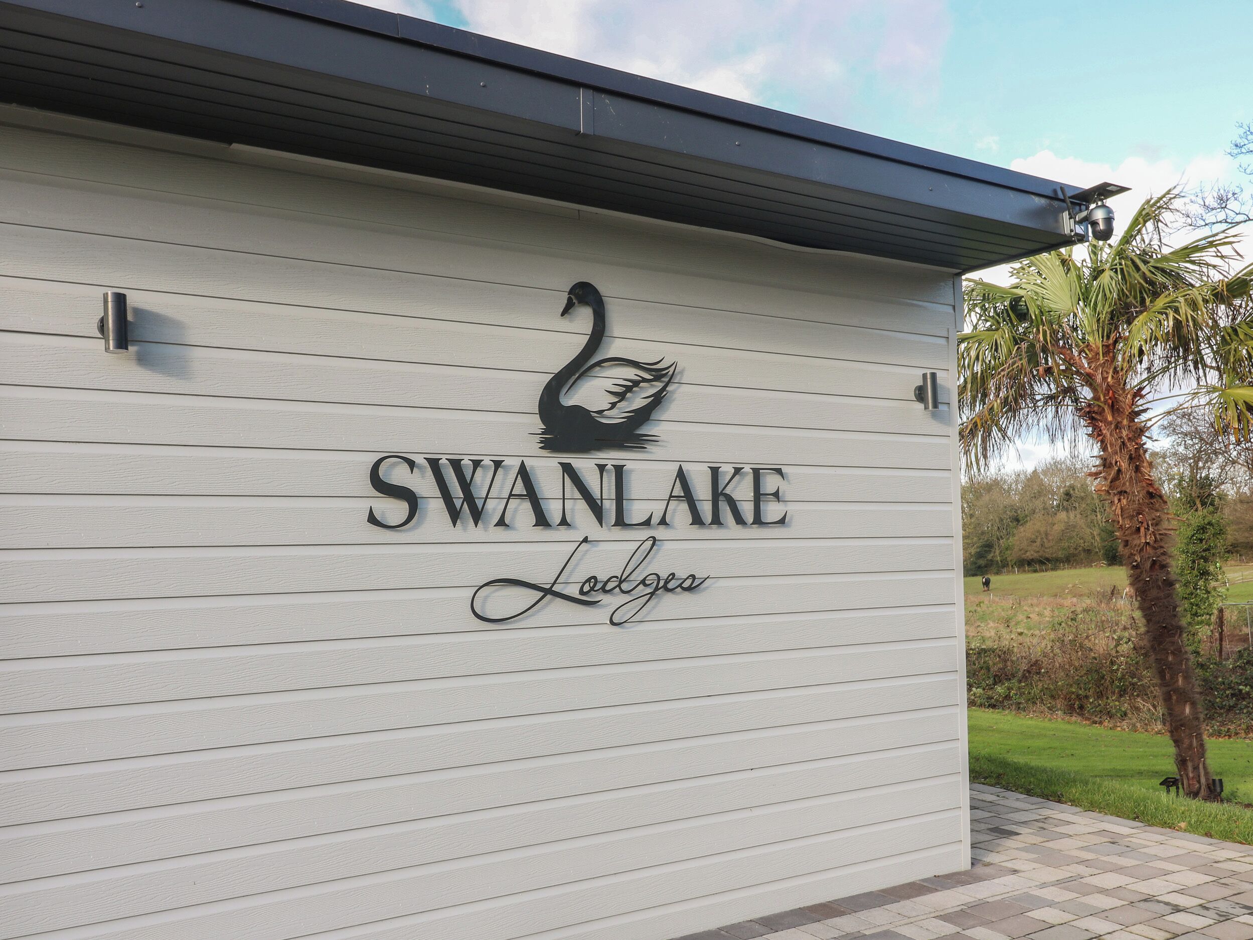 A building with a sign reading "SWAN LAKE Lodges" and a swan logo.