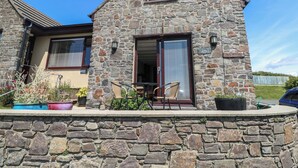 Una casa de piedra con un pequeño porche, una ventana y una puerta.