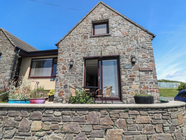 Una casa de piedra con un pequeño porche, una ventana y una puerta.