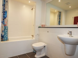 A bathroom with a bathtub, toilet, and sink.