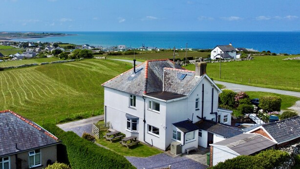 A coastal house with a paved driveway, a small garden, and a view of the sea. - Glynmor (Harlech)