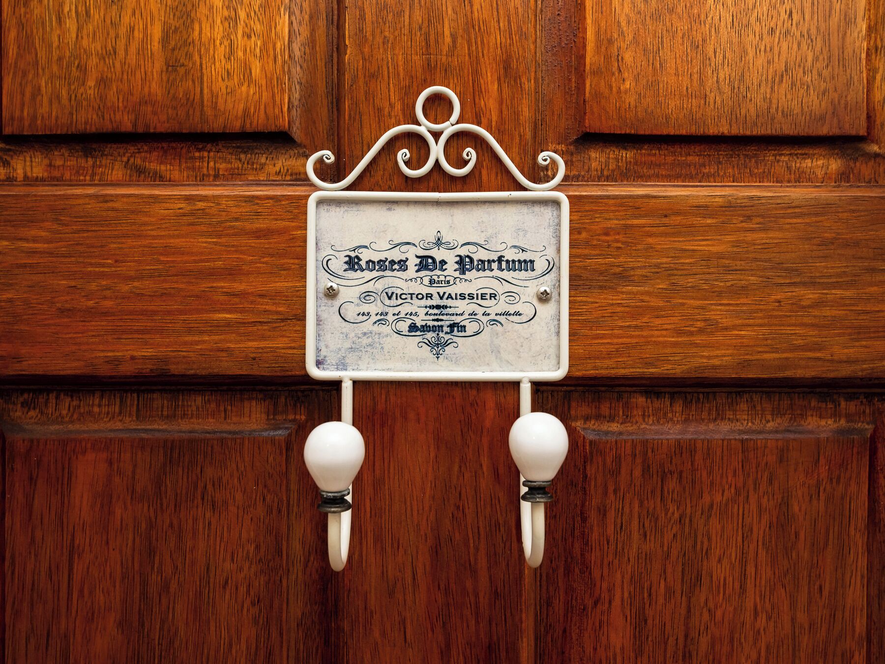 A wooden door with a vintage sign that reads "Roses De Partum" and "Victor Vaissier."