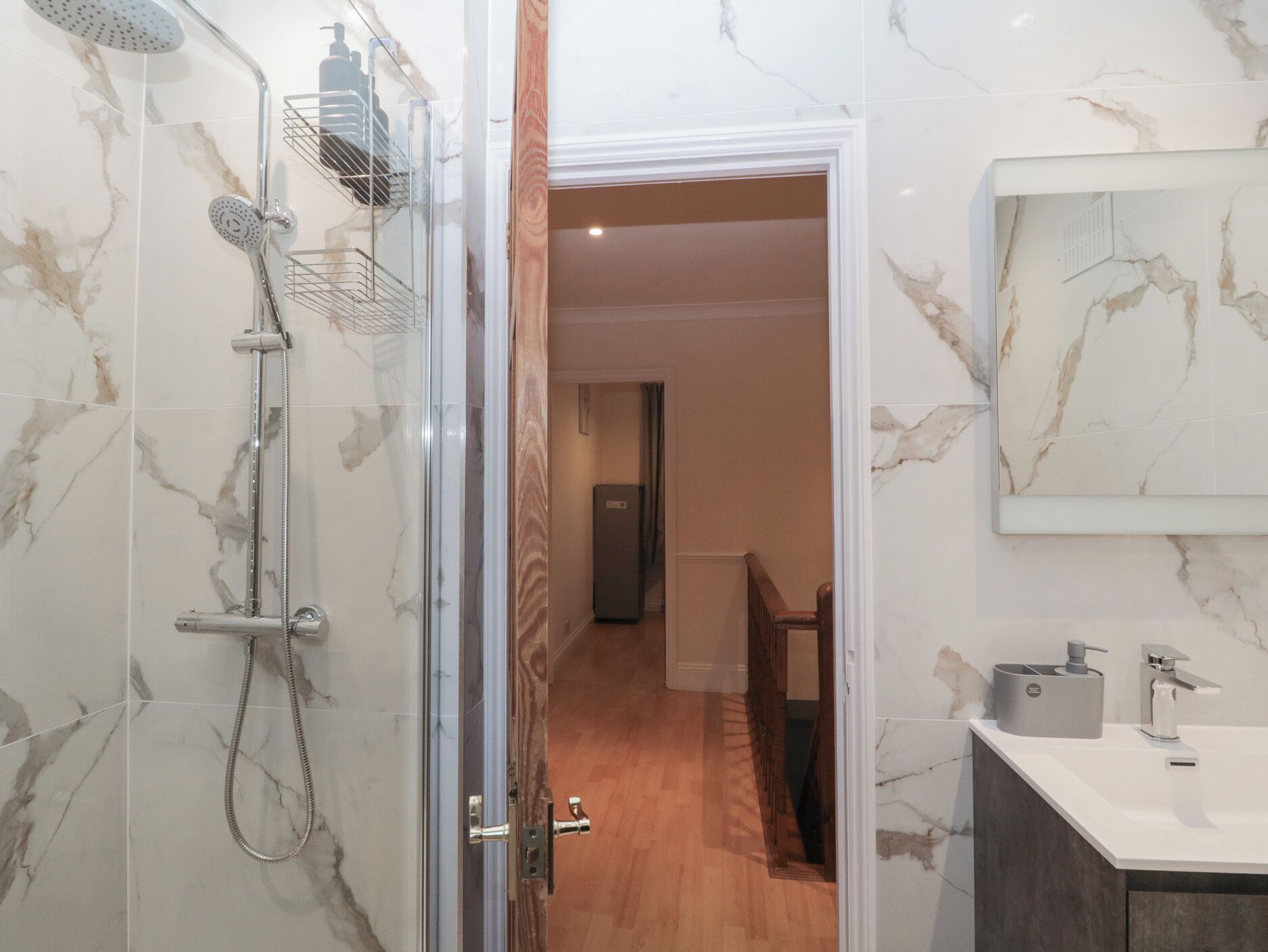 Un baño con ducha, lavamanos y espejo.