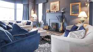 A living room with a fireplace, two sofas, and a chandelier. - Glenspey (Kingussie)