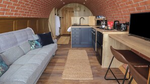 A compact kitchen with a wooden countertop, a sink, and a microwave.