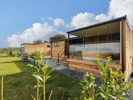 Un edificio moderno de madera con ventanas grandes y un patio cubierto.