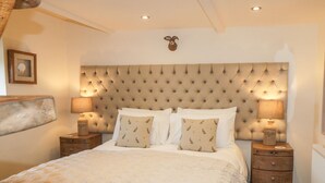 Una camera da letto con testiera trapuntata, due comodini con lampade e cuscini a fantasia.