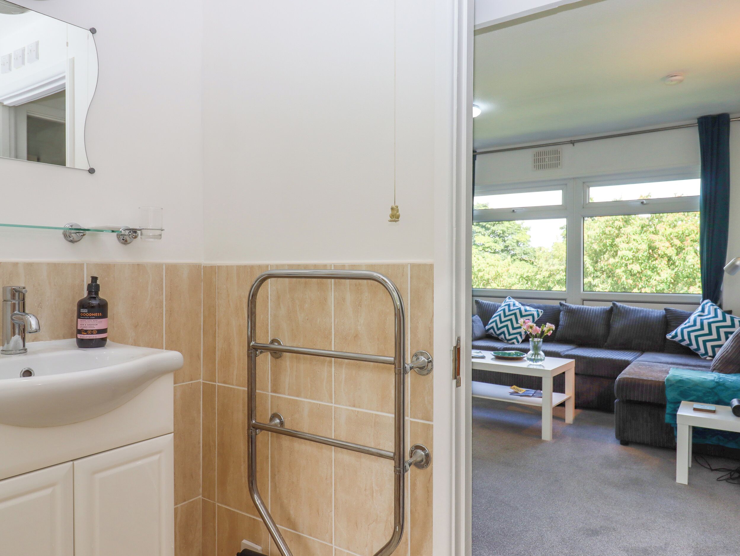A bathroom with a sink, mirror, and shower.