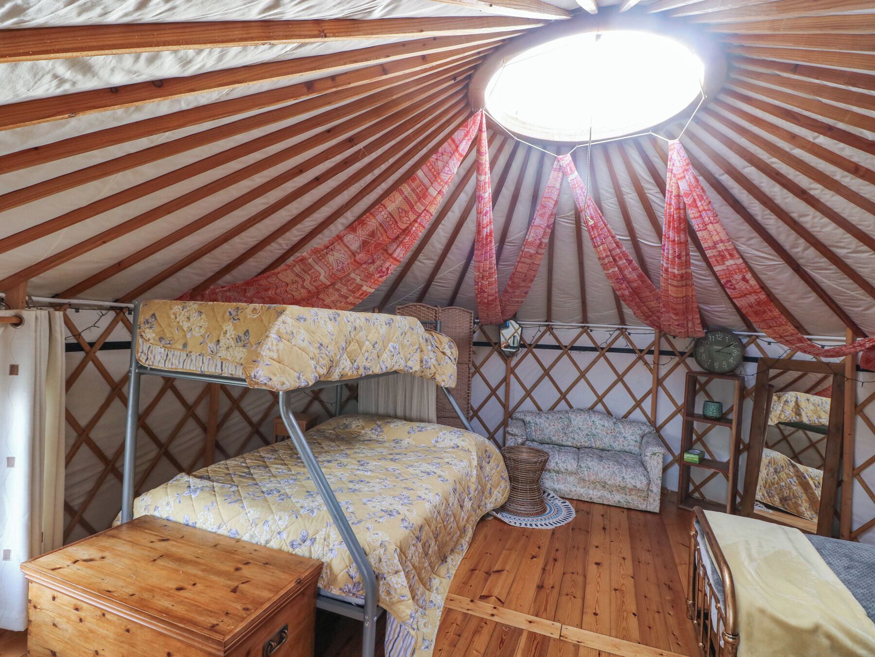 A cozy, well-lit tent with a bunk bed, a small table, and a cushioned bench.