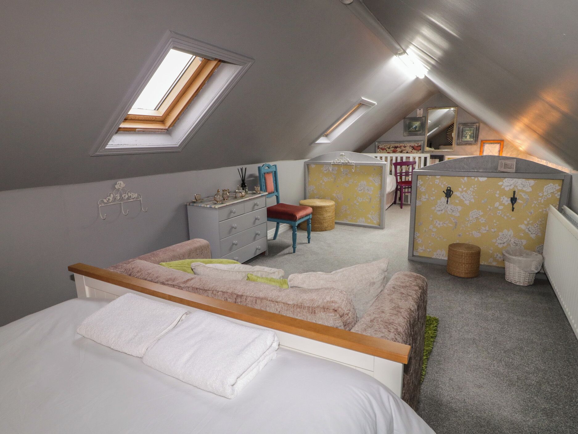 A bedroom with a bed, a dresser, a chair, a small table, and a window.