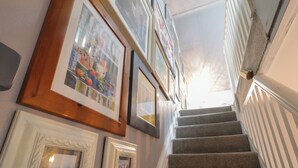 Una escalera con peldaños alfombrados y barandilla blanca.