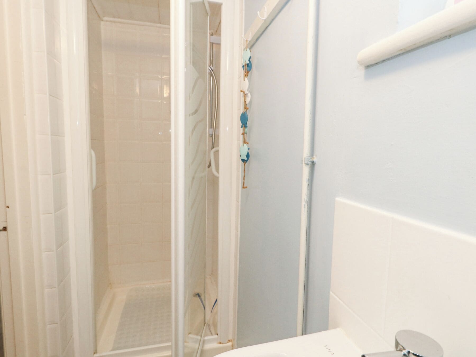 A bathroom with a shower area, a toilet, and a sink.