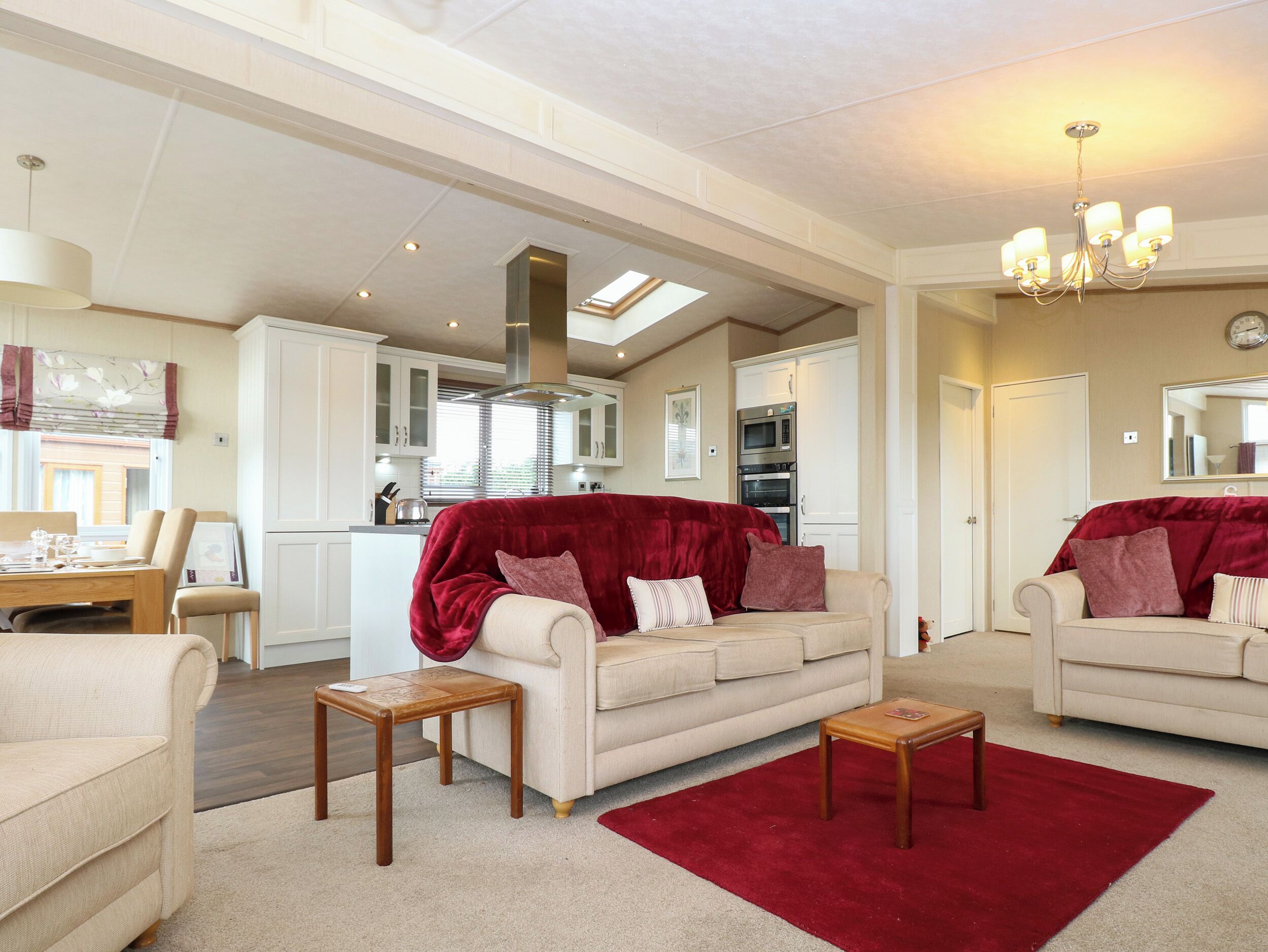 A spacious living room with a high ceiling, a dining area, and a kitchen with modern appliances.