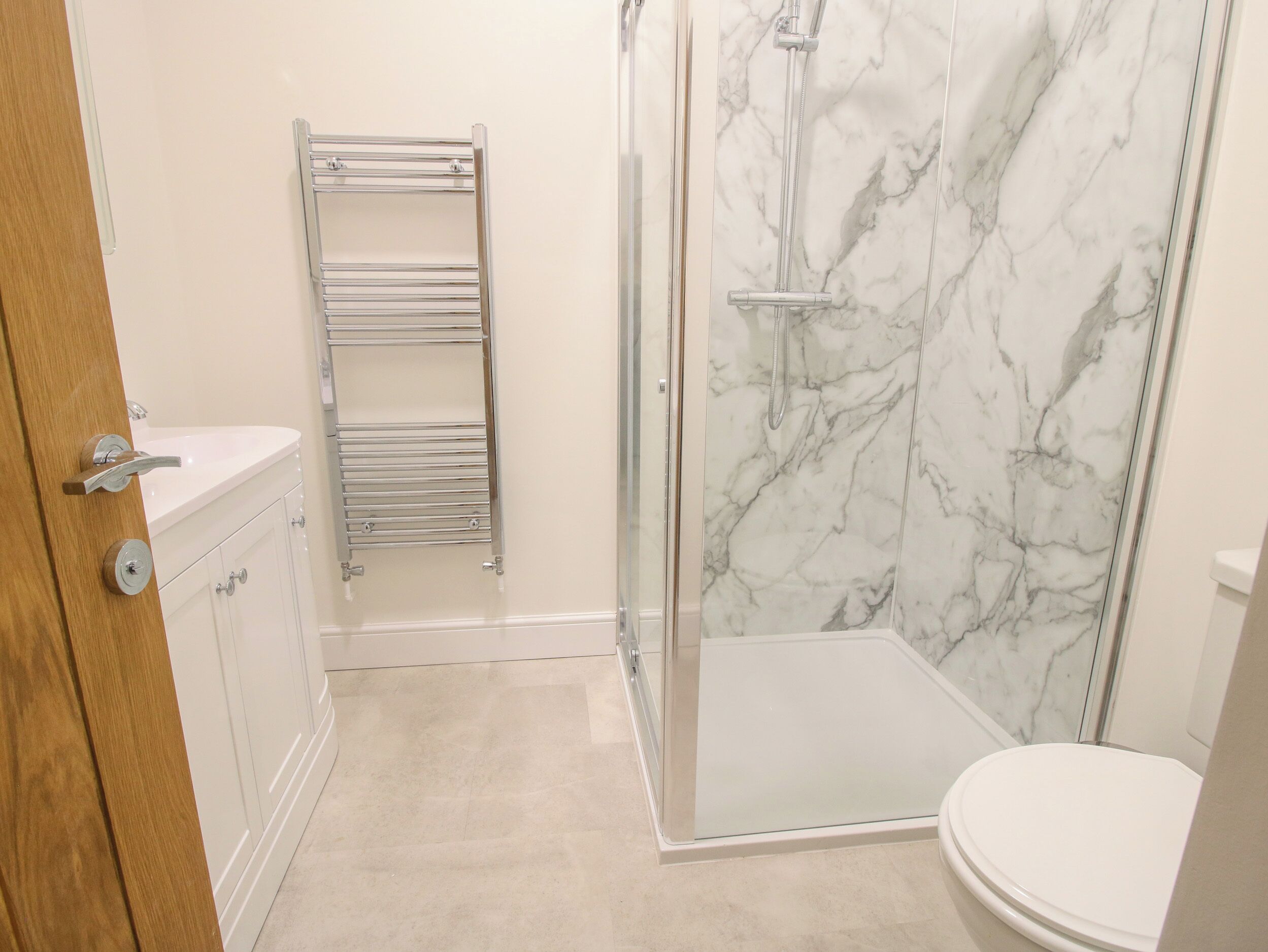 Une salle de bain avec douche, toilettes et porte-serviettes.