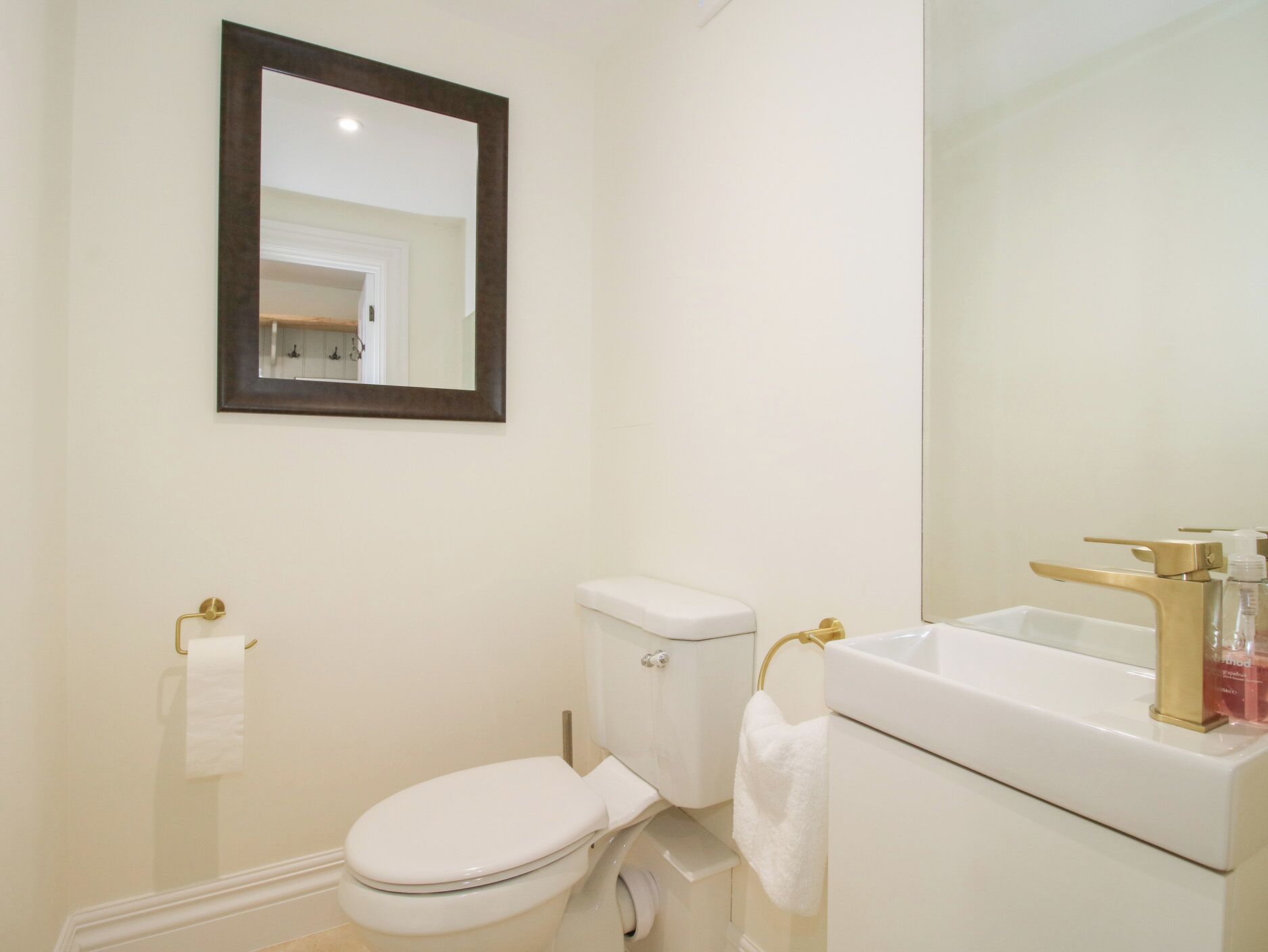 Une salle de bain avec des toilettes, un lavabo et un miroir.