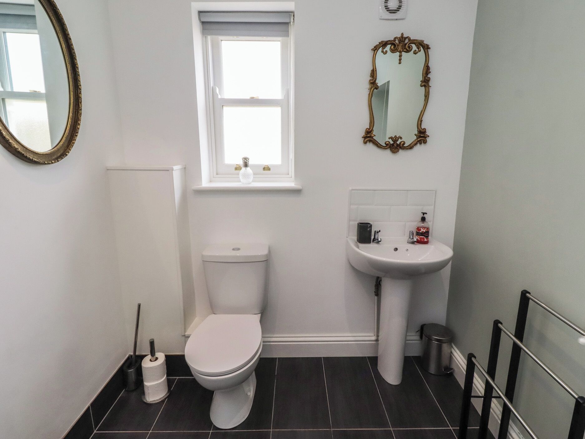 A small, clean bathroom with a toilet, sink, and window.