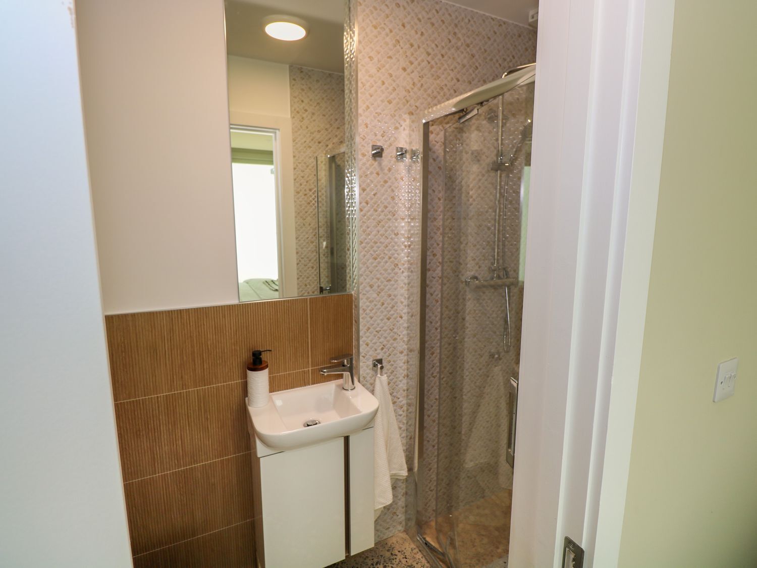 Ein Badezimmer mit Waschbecken, Spiegel und Dusche.