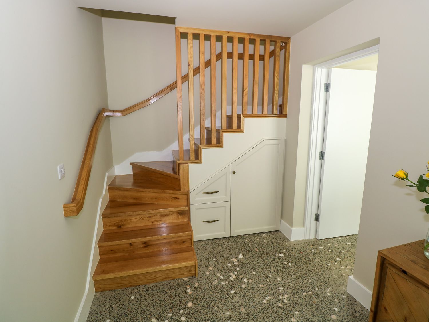 A wooden staircase with a white door at the top.