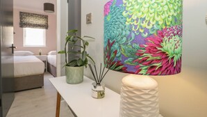 Una camera da letto moderna con un letto, un comodino e una lampada grande con decori floreali.