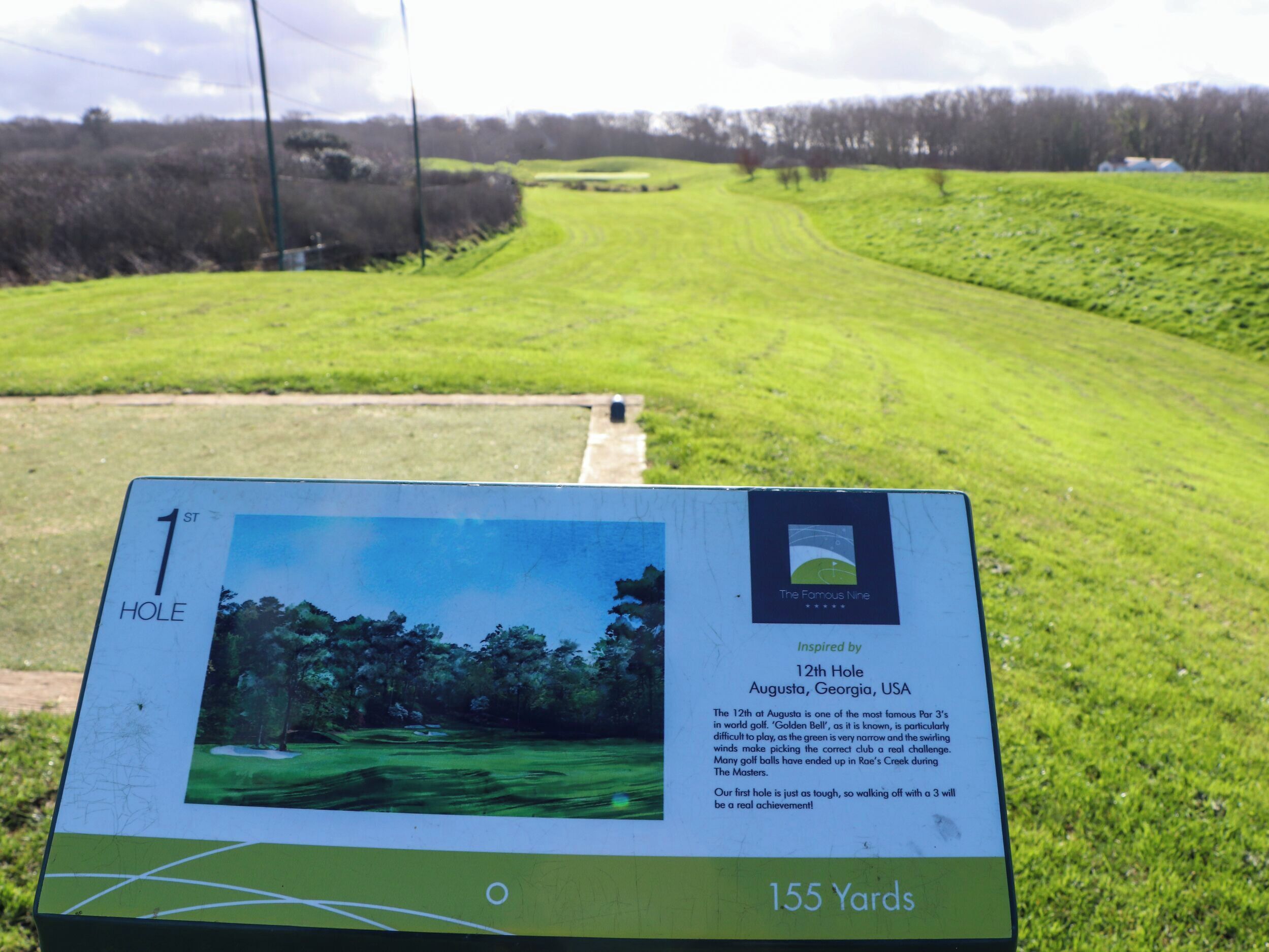 Skilt på golfbane der angiver bane 1, 155 yards, og inspireret af Augusta, Georgia, USA.