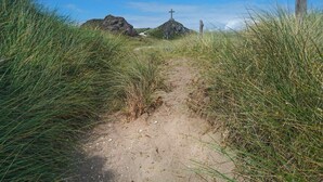 A dirt path leading to a rocky area with a cross monument. - Caeau Gwynion Farm (Llanfairpwllgwyngyll)