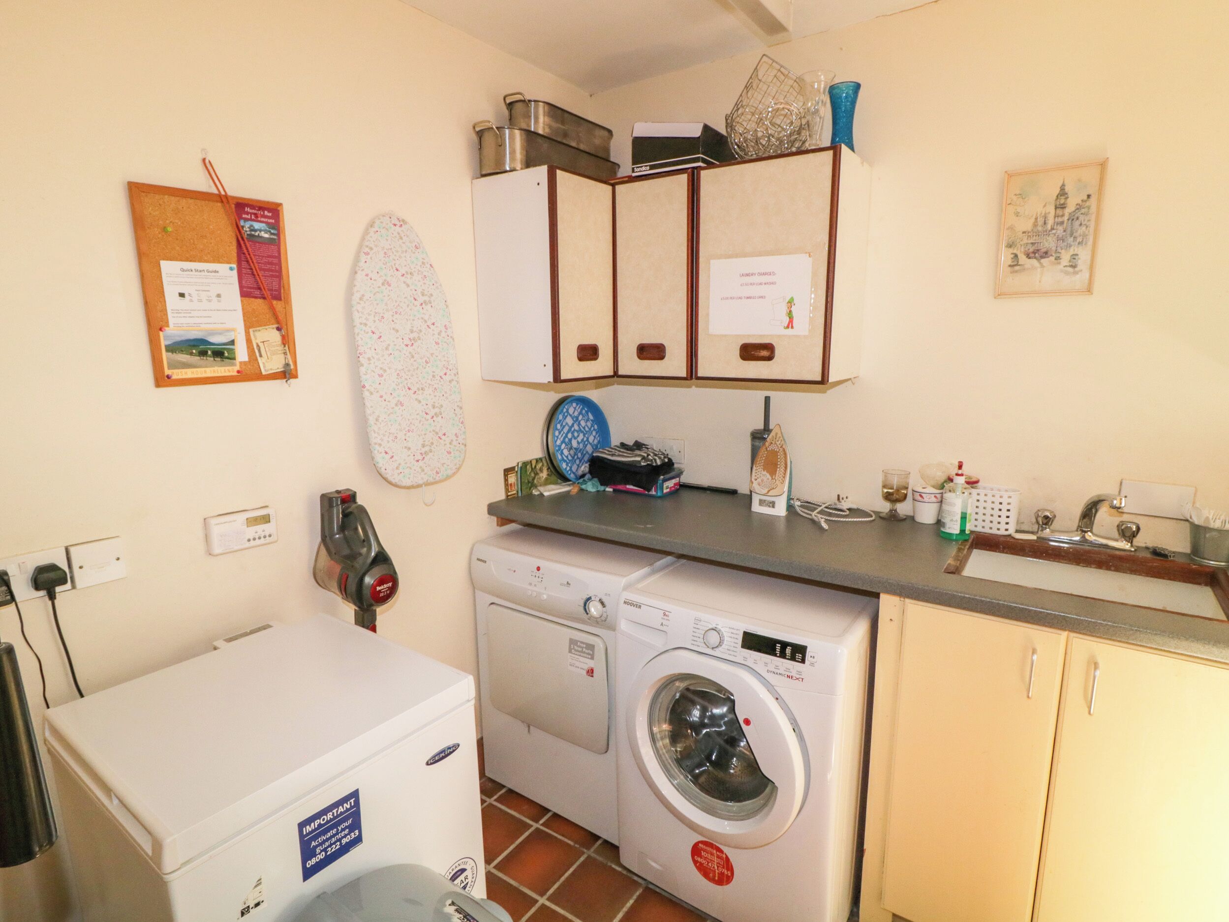 A compact kitchen with a washing machine, a small refrigerator, and a countertop with various items.