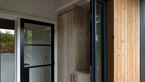 A room with a sliding glass door, wooden cabinets, and a view of greenery outside. - The Lookout (Preston)