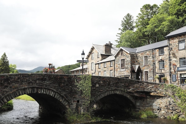 A stone bridge over a river with buildings on either side, including a pub named "Robinsons".