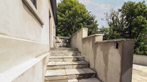 A set of stone steps leading up to a building entrance, with a small table and chairs nearby. - Hogans Cottage (Ennistimon)