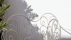 Ένα μεταλλικό πλαίσιο κρεβατιού με περίτεχνο διακοσμητικό σχέδιο σε στυλ σπειροειδούς.