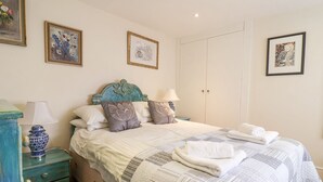 A bedroom with a bed, nightstands, a dresser, and artwork on the walls.