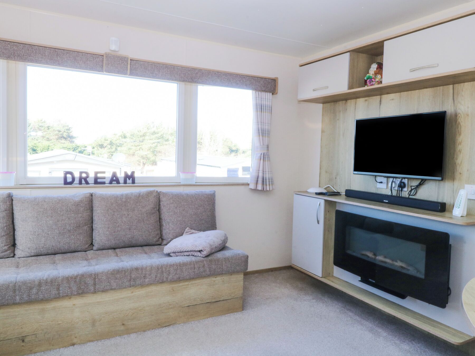 A cozy living room with a sofa, a television, and a small cabinet.